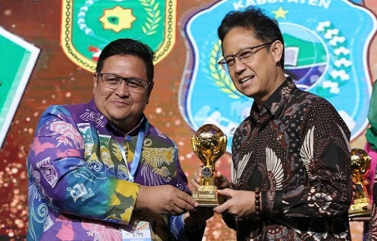 Wakil Bupati Nabire, Ismail Djamaluddin, saat menerima UHC Award dari Menkes RI, Budi Sadikin. Foto: Ist